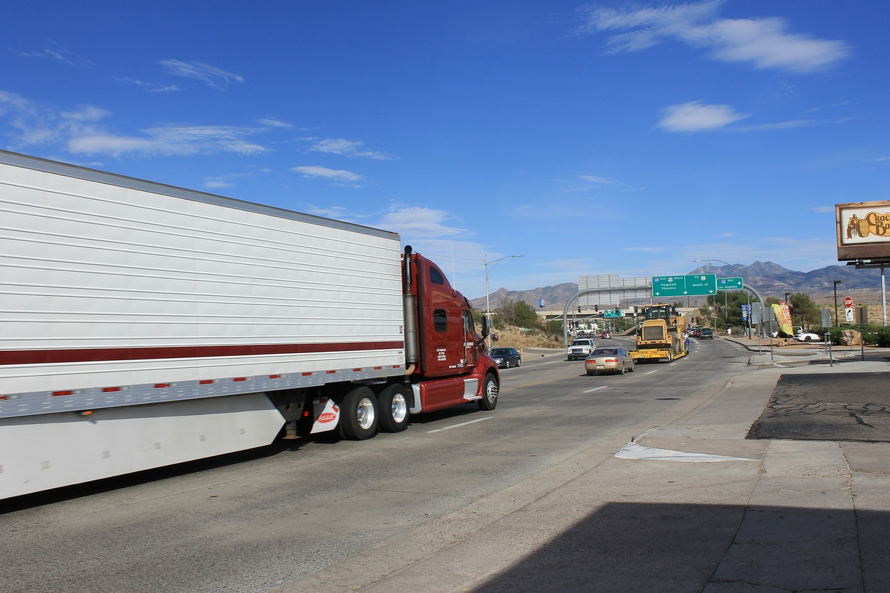 A semi truck is driving down the street.